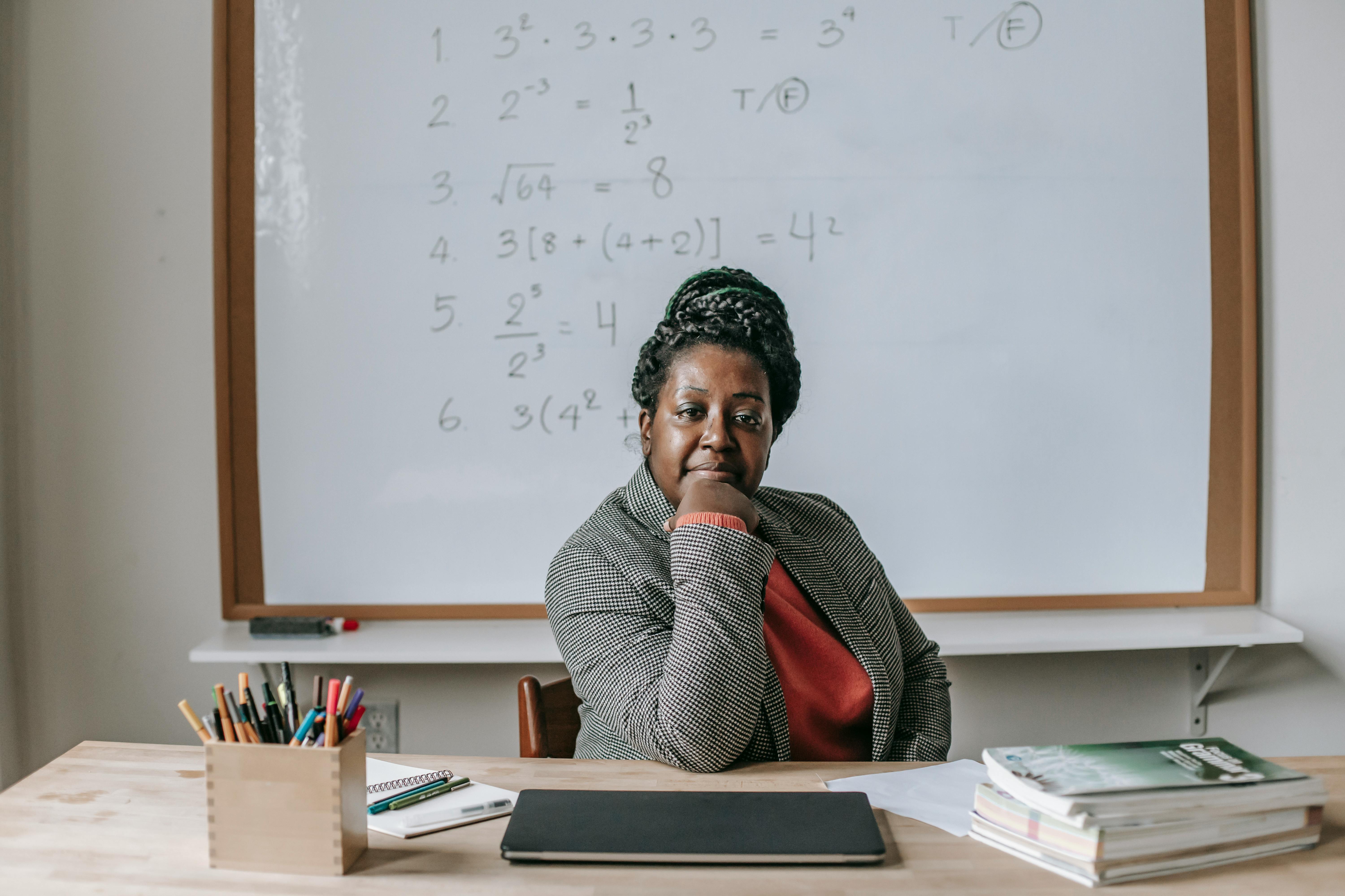 A teacher sitting on their desk